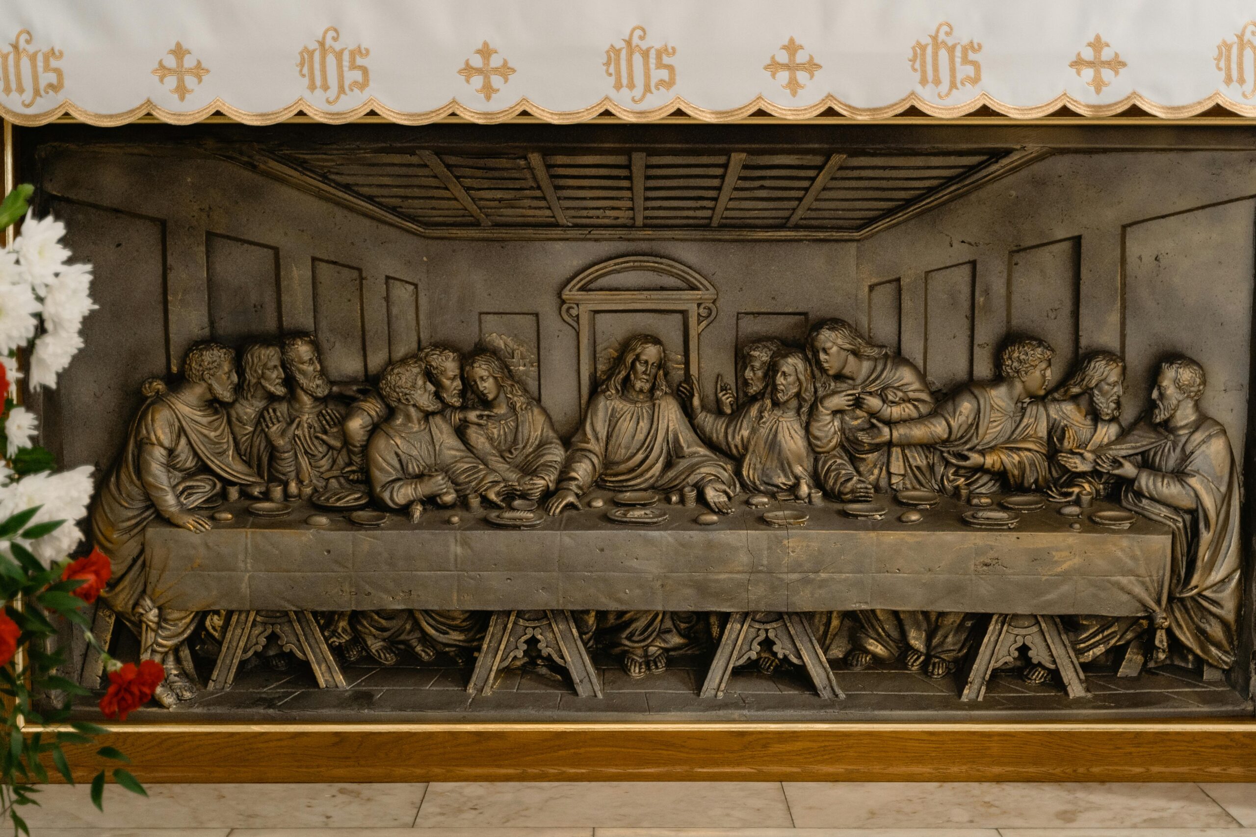 Close-up view of a detailed Last Supper metal relief sculpture, symbolizing a famed biblical scene.